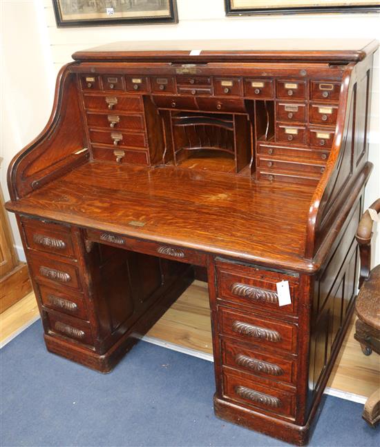 An early 20th century oak roll top desk, with well fitted interior, W.128cm H.128cm D.89cm